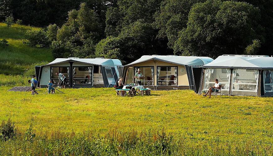 Luxury Glamping Tents In Green Meadow With People Relaxing