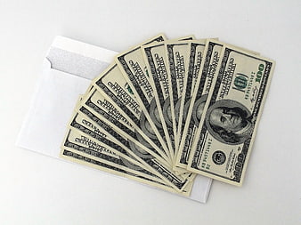 Stack of hundred dollar bills in white envelope