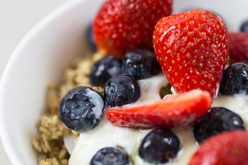 Close-up of fresh strawberries and blueberries on yogurt and granola