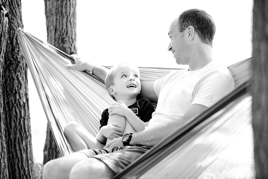 Father and Son Laughing Together in Hammock
