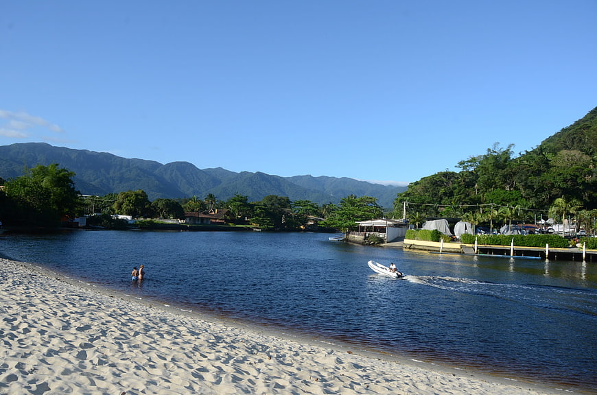Sandy beach with river, mountains, and boat in Costa Rica