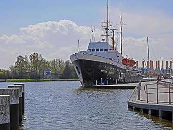Historic black pilot boat Kapitan Bleeker docked at harbor