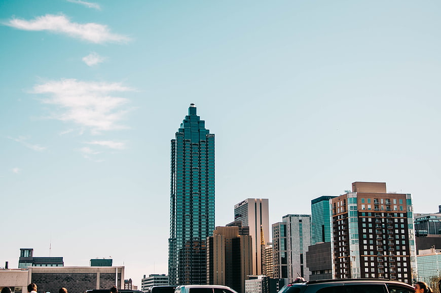 Modern city skyline with teal skyscraper and blue sky