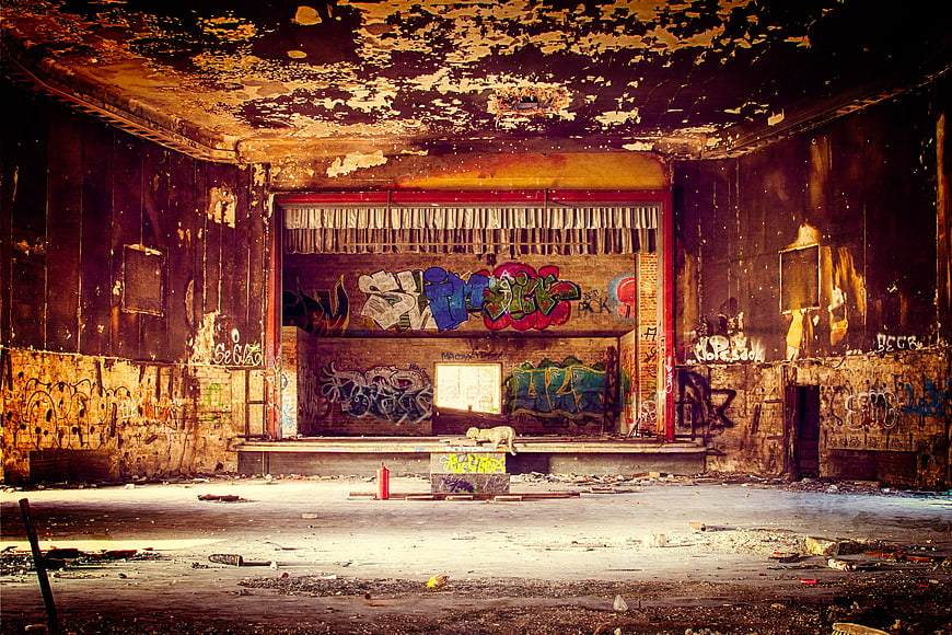 Abandoned Theater Interior With Colorful Graffiti And Peeling Walls