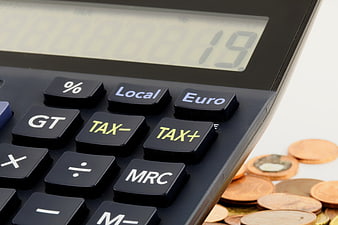 Close-up of calculator with tax buttons and euro coins