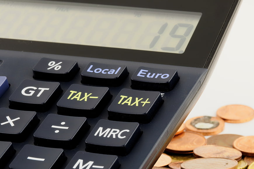 Close-up of calculator with tax buttons and euro coins