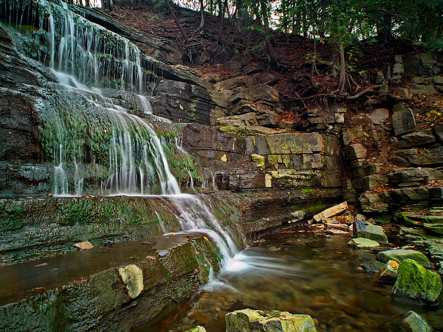 Serene Waterfall Cascading Over Mossy Rocks in Forest
