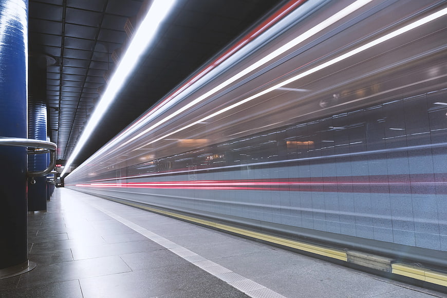 Motion blur subway train speeding through underground station