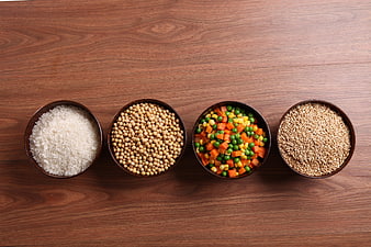 Top View of Four Bowls With Rice, Soybeans, Veggies, Grains