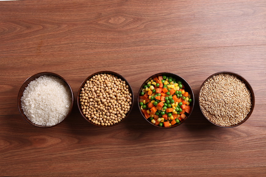 Top View of Four Bowls With Rice, Soybeans, Veggies, Grains
