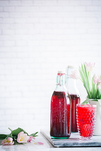 Pink Tulips and Red Berry Juice in Glass Bottles