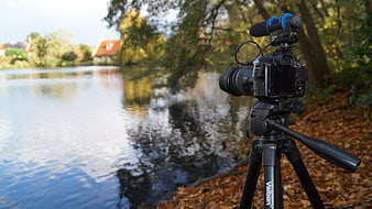 DSLR Camera on Tripod Filming Scenic Autumn Lake
