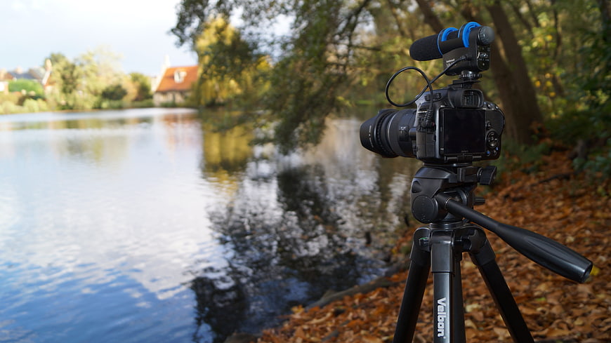 DSLR Camera on Tripod Filming Scenic Autumn Lake