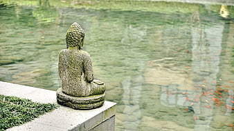 Stone Buddha Statue Meditating by Koi Pond