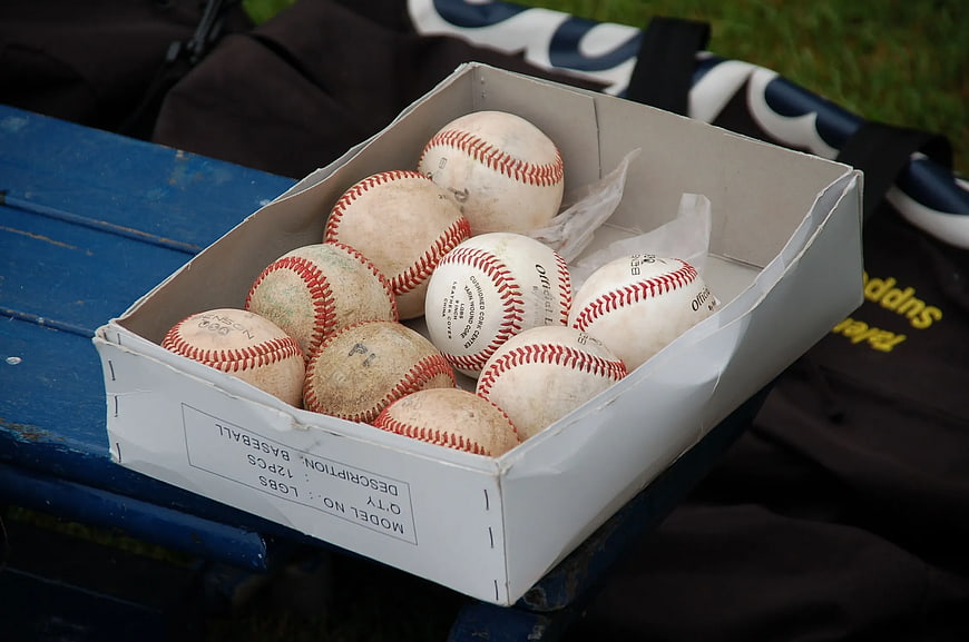 Box of Used Baseballs on Blue Bench