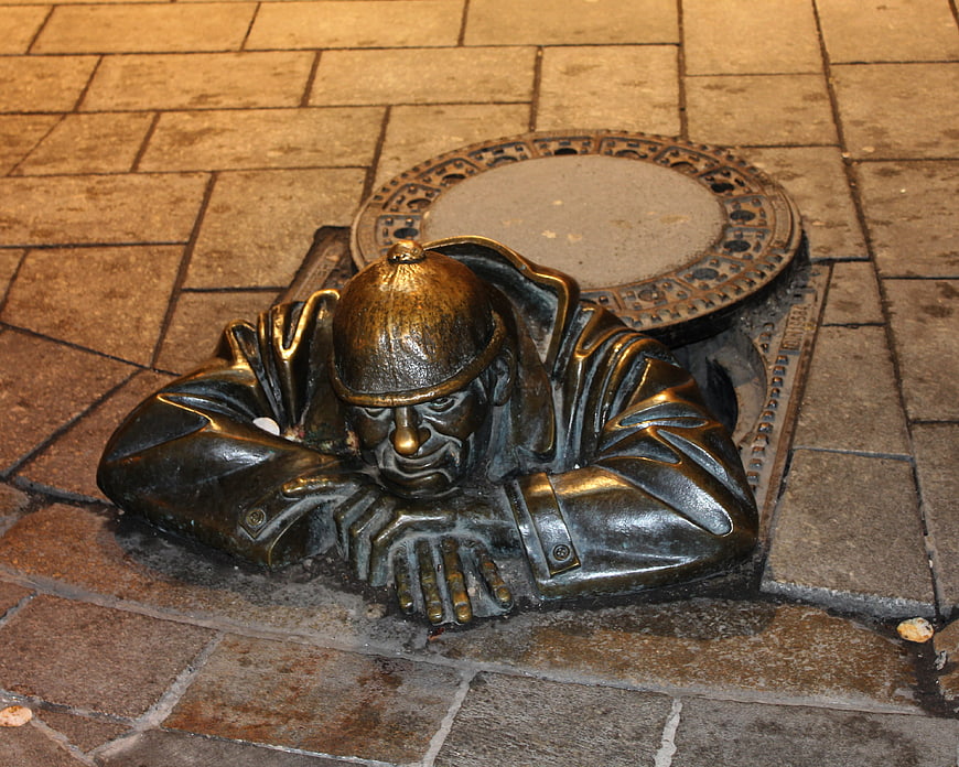 Bronze Sherlock Holmes statue emerging from manhole in Prague