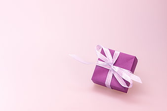 Purple Gift Box With White Ribbon On Pink Background