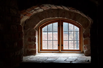 Arched wooden window in rustic stone wall interior