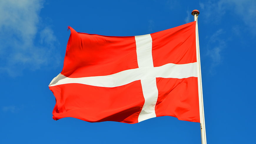 Danish Flag Waving Against Blue Sky