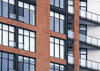 Modern Brick Building Facade with Black Windows and Balconies