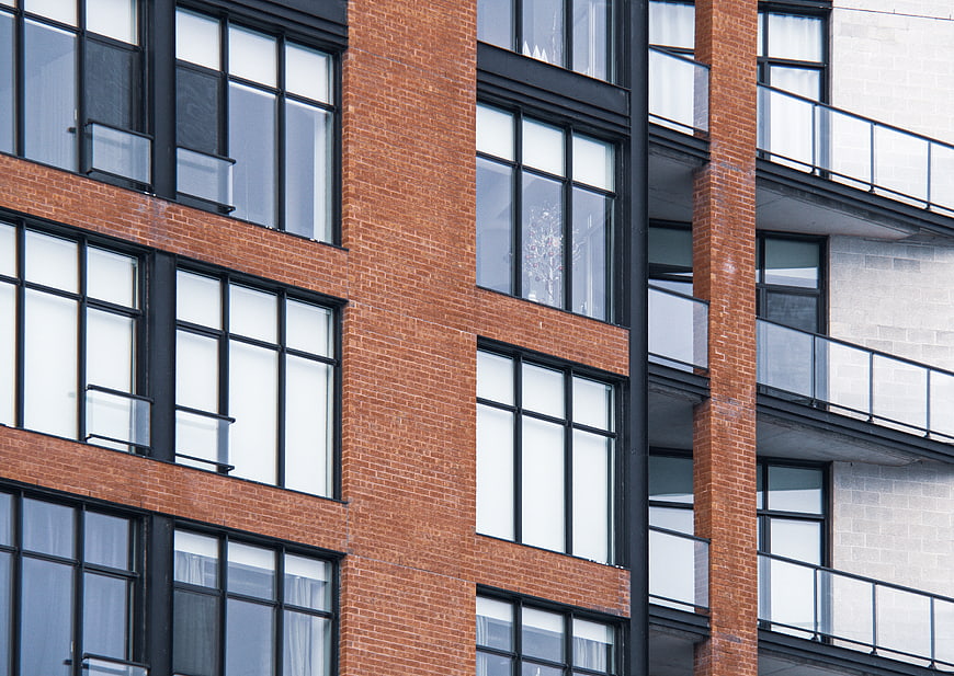 Modern Brick Building Facade with Black Windows and Balconies