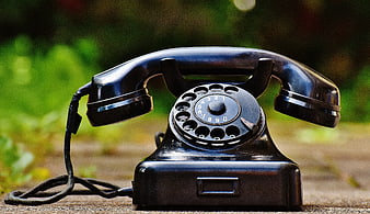 Vintage Black Rotary Dial Telephone on Wooden Surface