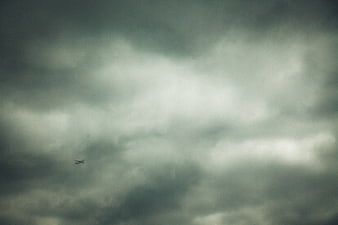 Small airplane flying through dark stormy clouds