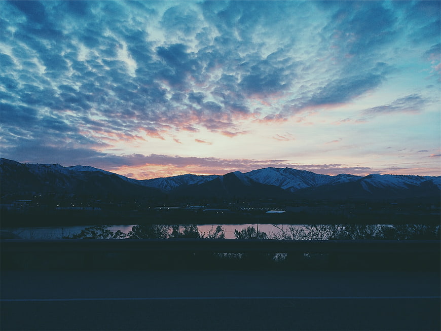 Dramatic sunset over snow-capped mountains and lake