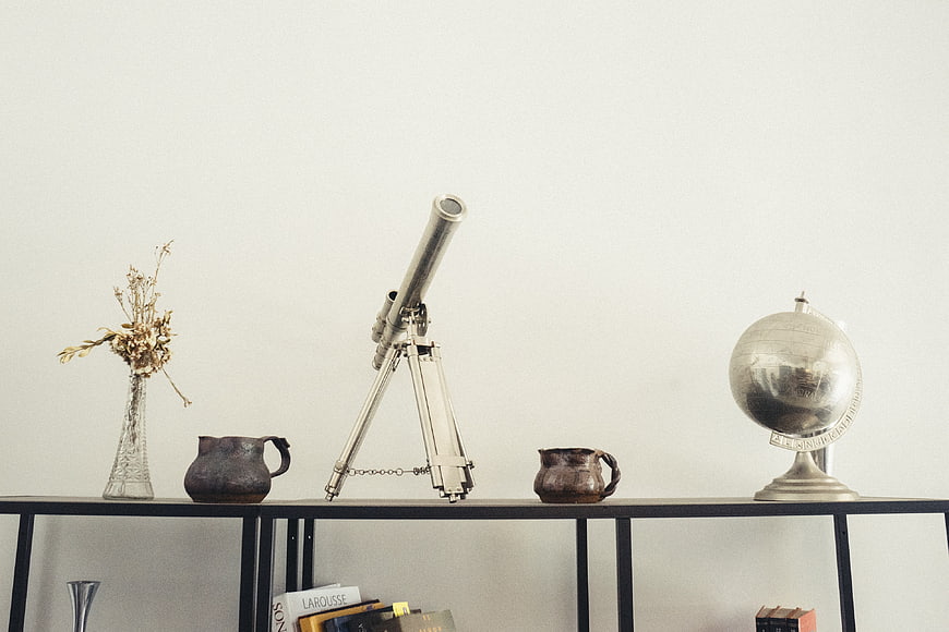 Vintage Telescope and Silver Globe on Minimalist Shelf