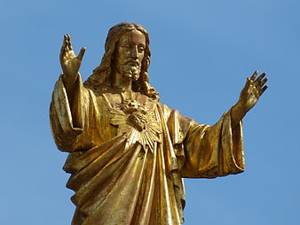 Golden Sacred Heart of Jesus Statue Against Blue Sky