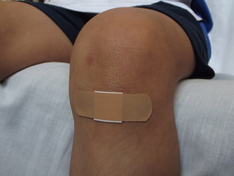 Close-up of child's knee with adhesive bandage