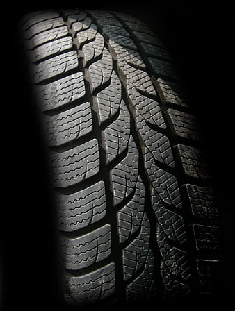 Close-up of winter tire tread pattern on black background