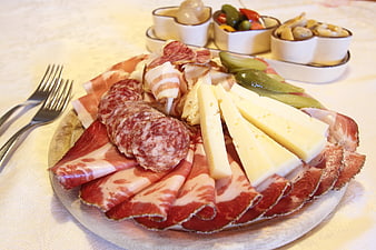 Assorted cured meats, salami, and cheese platter on a white plate