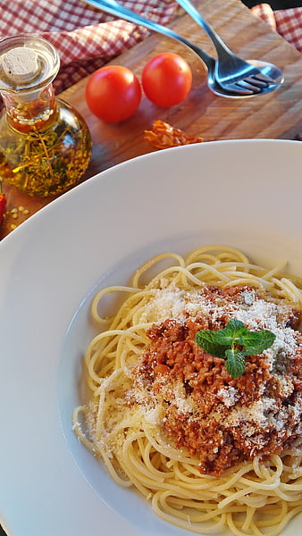 Spaghetti Bolognese with Parmesan and Mint on a White Plate