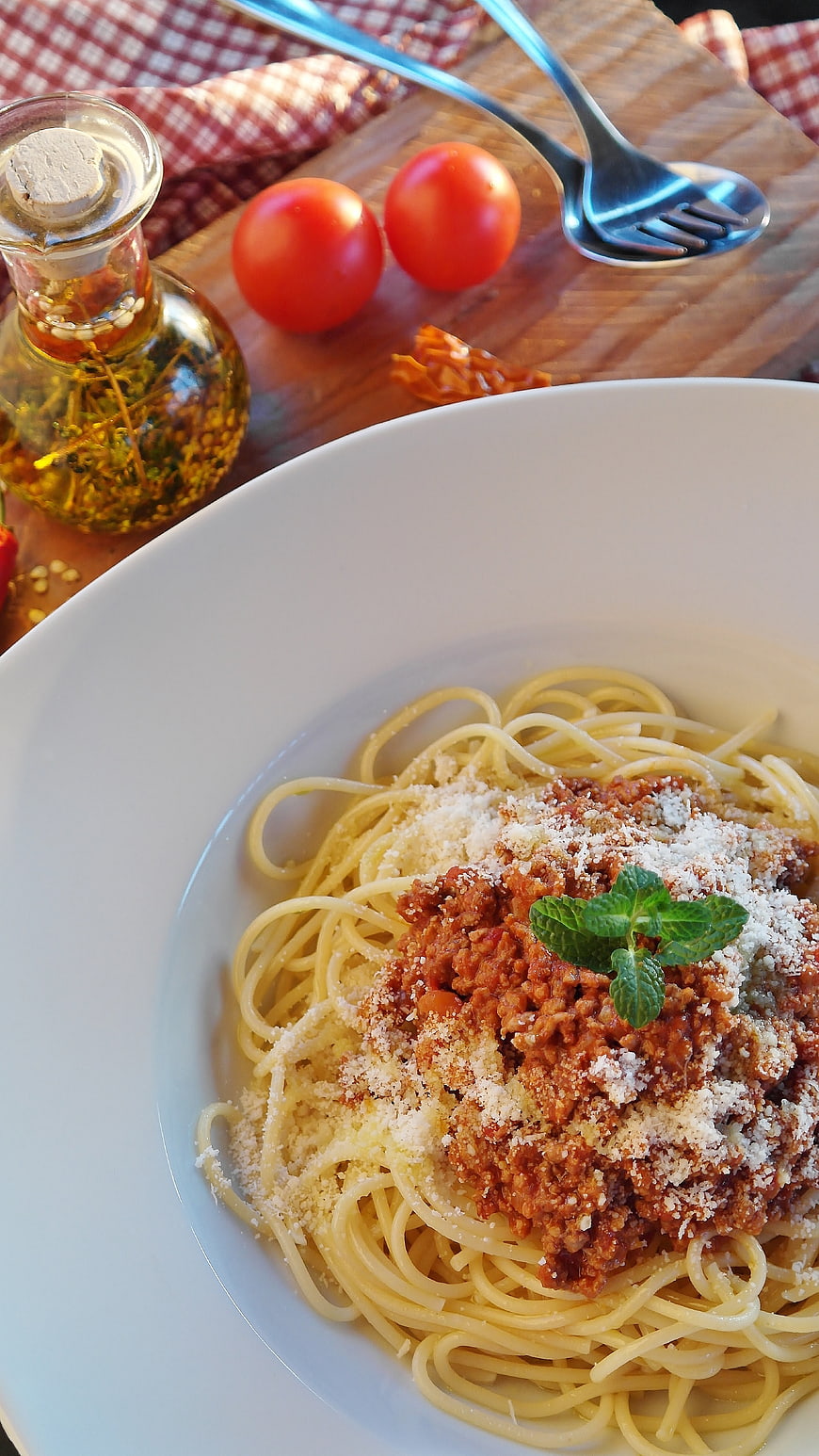 Spaghetti Bolognese with Parmesan and Mint on a White Plate