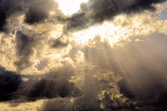 Dramatic Sunbeams Breaking Through Dark Storm Clouds