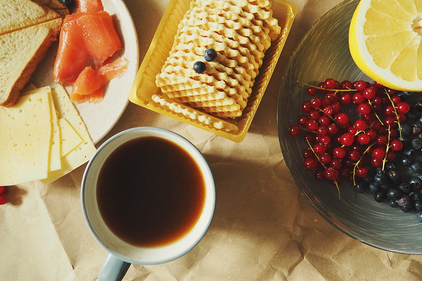 Overhead view of coffee, waffles, cheese, salmon, and berries