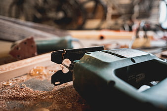 Close-up of electric jigsaw on workbench with sawdust