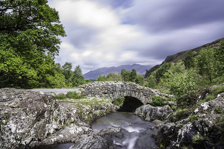 Old Stone Bridge Over Stream in Mountain Valley