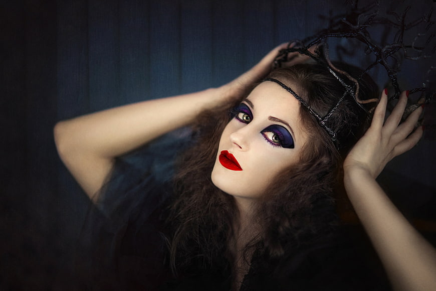 Gothic woman with dramatic purple eye makeup and red lips
