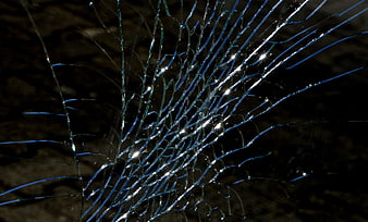 Close-up of shattered glass with blue reflections and bright highlights