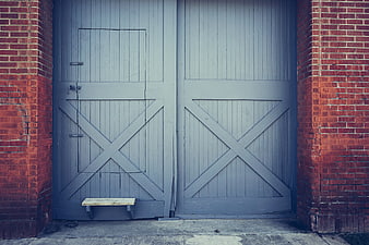 Gray Barn Doors with Red Brick Walls and Wooden Step