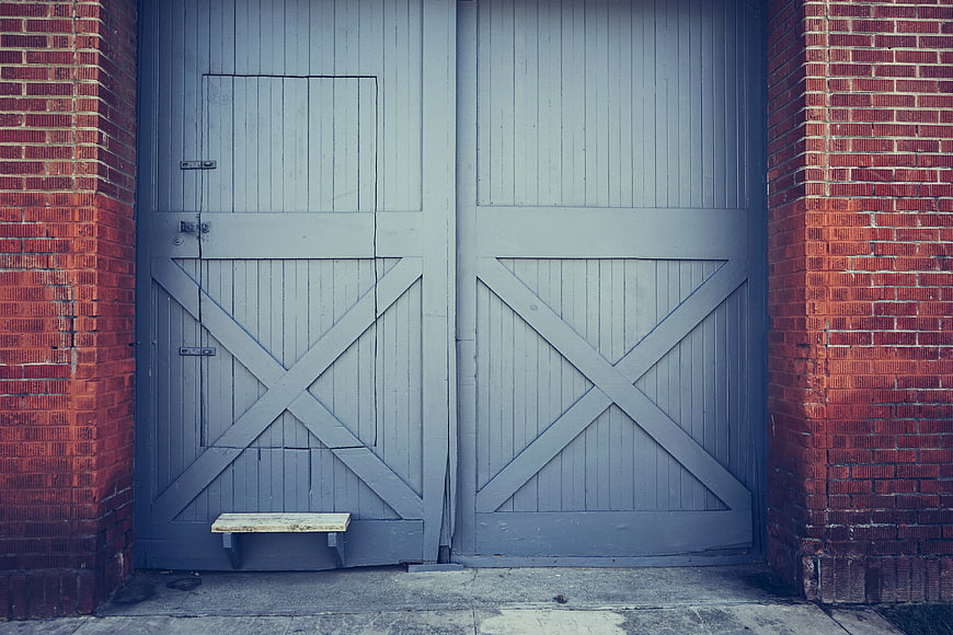 Gray Barn Doors with Red Brick Walls and Wooden Step