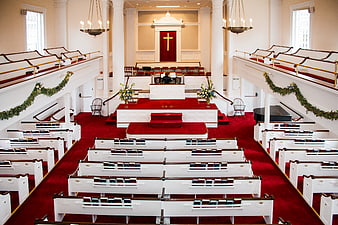 Interior of a traditional church with red carpet and white pews