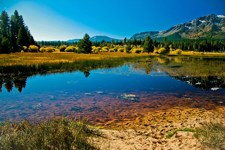 Serene Mountain Lake with Golden Autumn Reflections