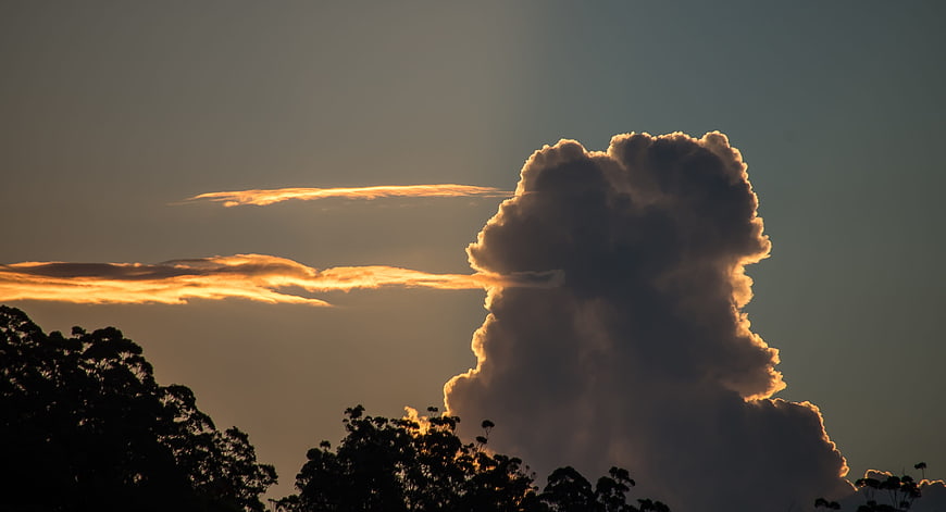 Dramatic sunset cloud formation over silhouetted trees