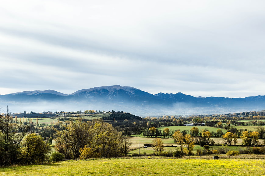 Serene Autumn Landscape with Rolling Hills and Misty Mountains