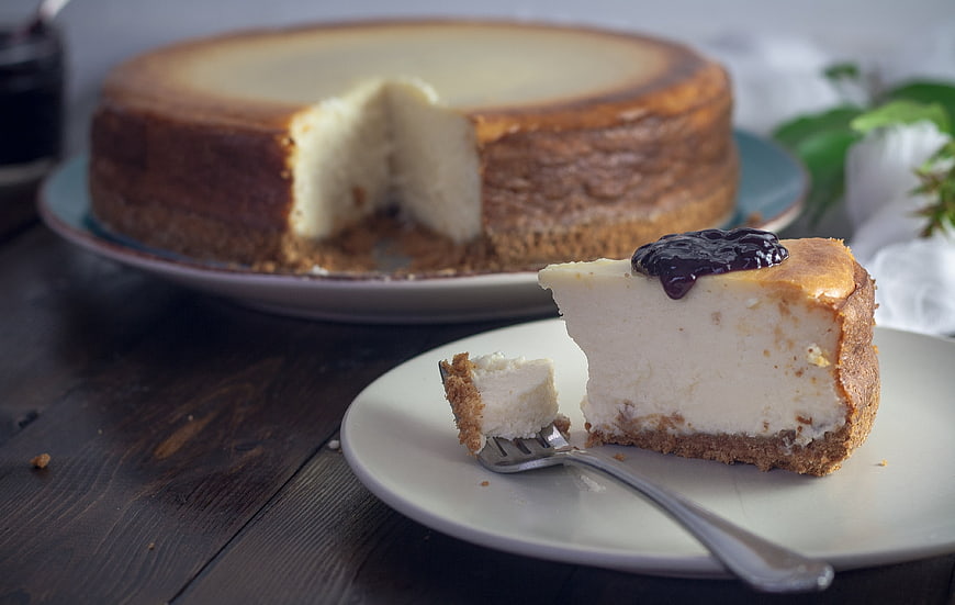 Creamy Cheesecake Slice with Berry Topping on Wooden Table