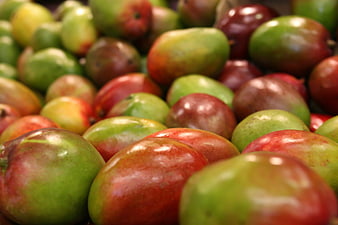 Close-up of fresh red and green mangoes in a pile