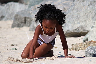 Young African Girl Playing in Sand on Beach